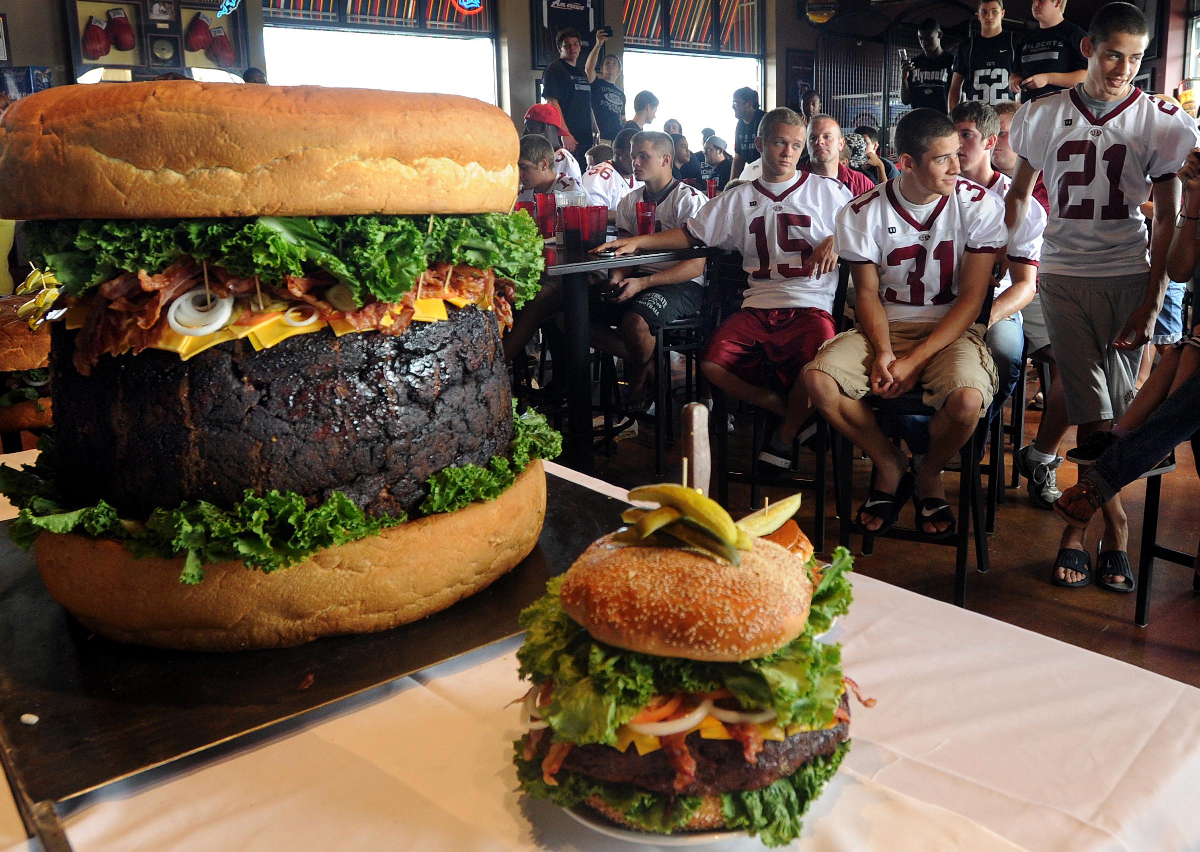 A member of the Southgate Anderson High School football team attempts to eat his share of a 300-pound hamburger at Mallie’s Sports Bar & Grill. (Photo by Dave Chapman)